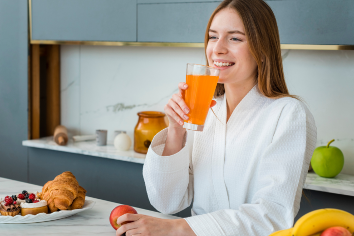 Žena pije sok, kuhinja